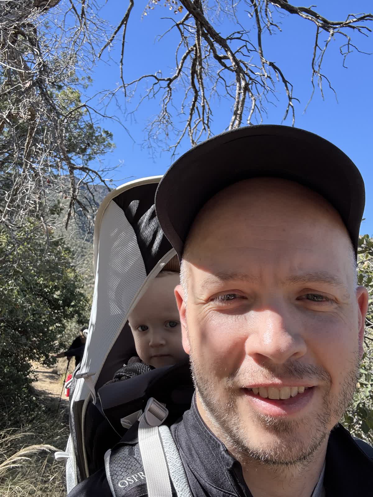 Ben hiking with his son in a child carrier